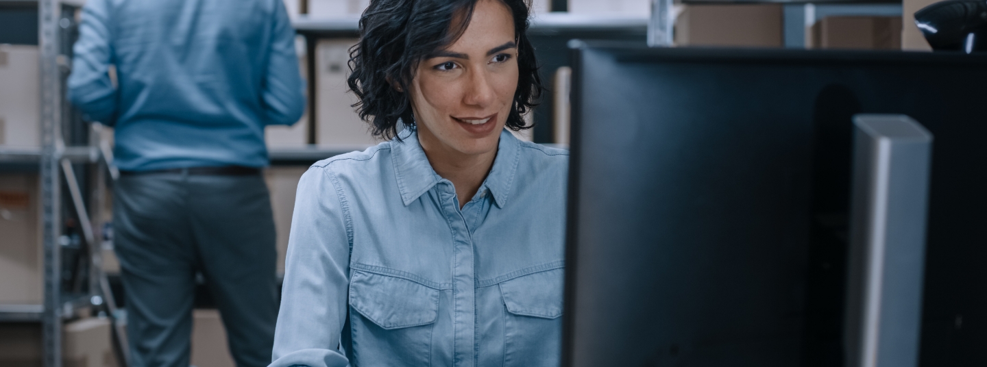 Lady in a warehouse ordering sustainable products from her computer